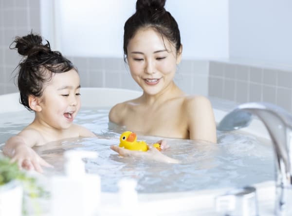 浴室で遊ぶ子供と母親の写真