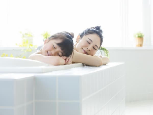 母と娘が浴室でくつろいでいる様子 イメージ写真