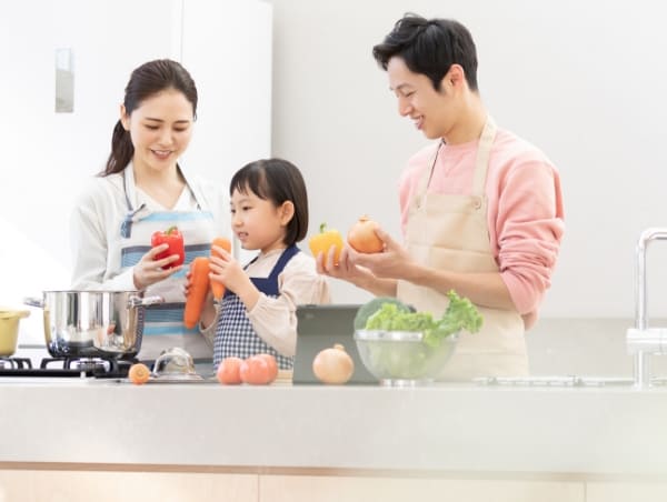家族がキッチンで料理をしている様子 イメージ写真