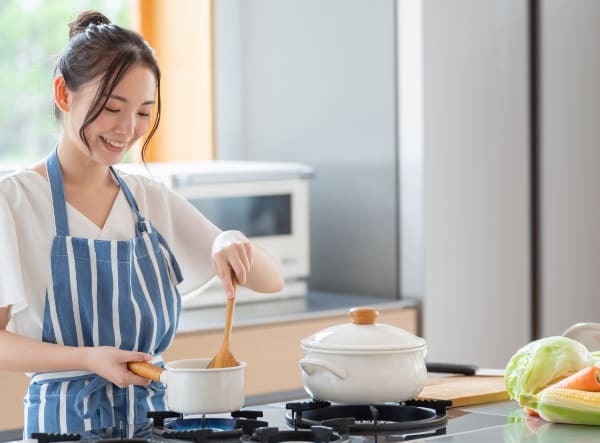 キッチンで料理をしている女性の写真