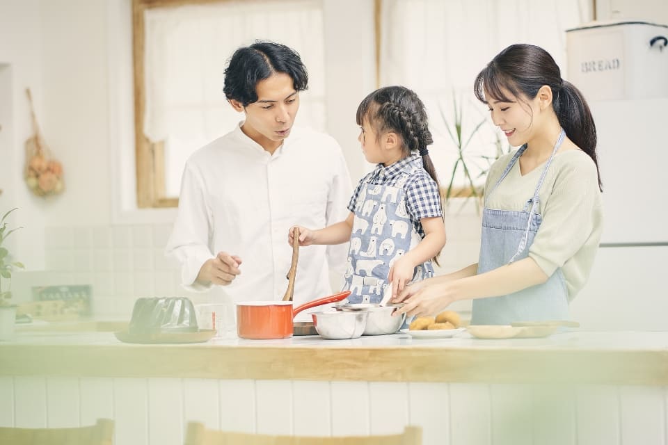 家族がキッチンで料理をしている写真