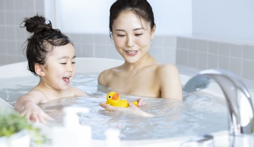 浴室で遊ぶ子供と母親の写真