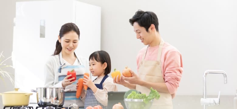 家族がキッチンで料理をしている様子 イメージ写真