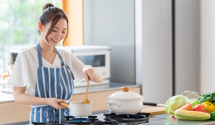 キッチンで料理をしている女性の写真