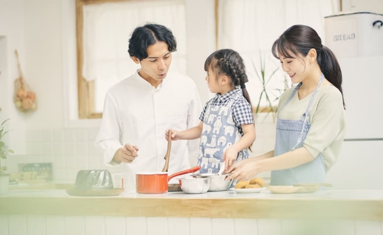 家族がキッチンで料理をしている写真