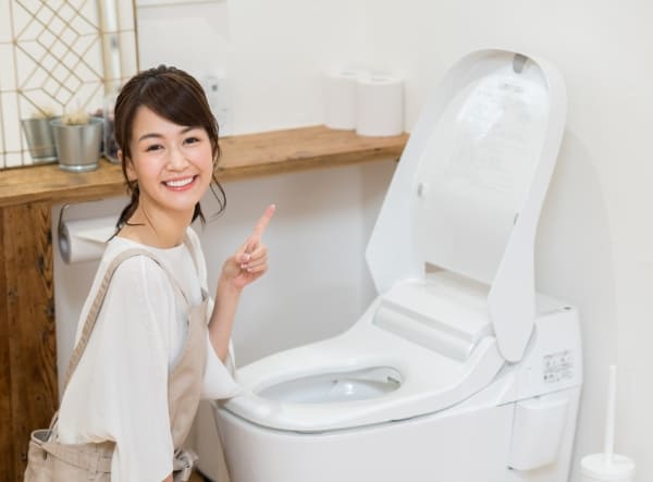 笑顔でトイレに居る女性の写真